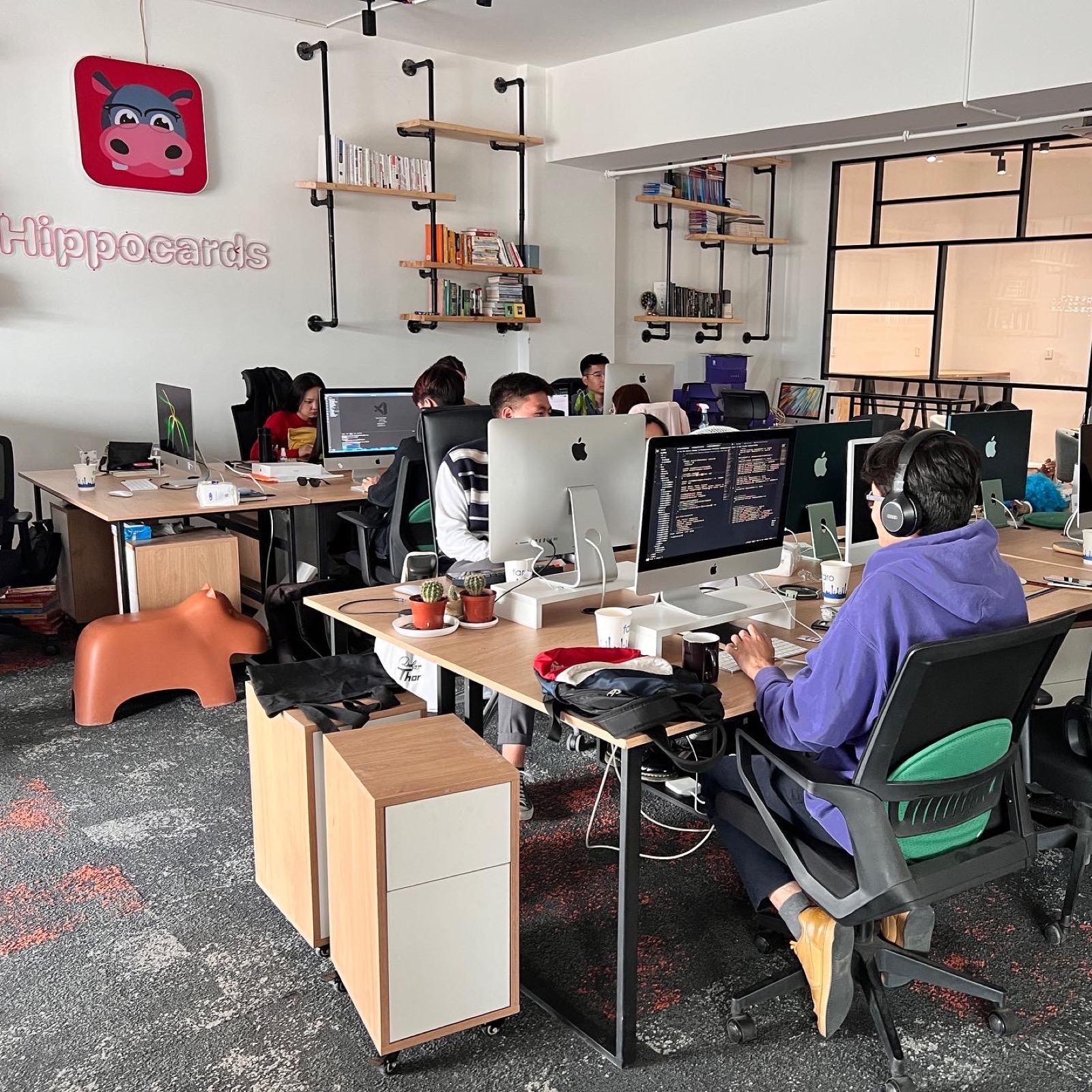 HippoCards team working beneath the company sign