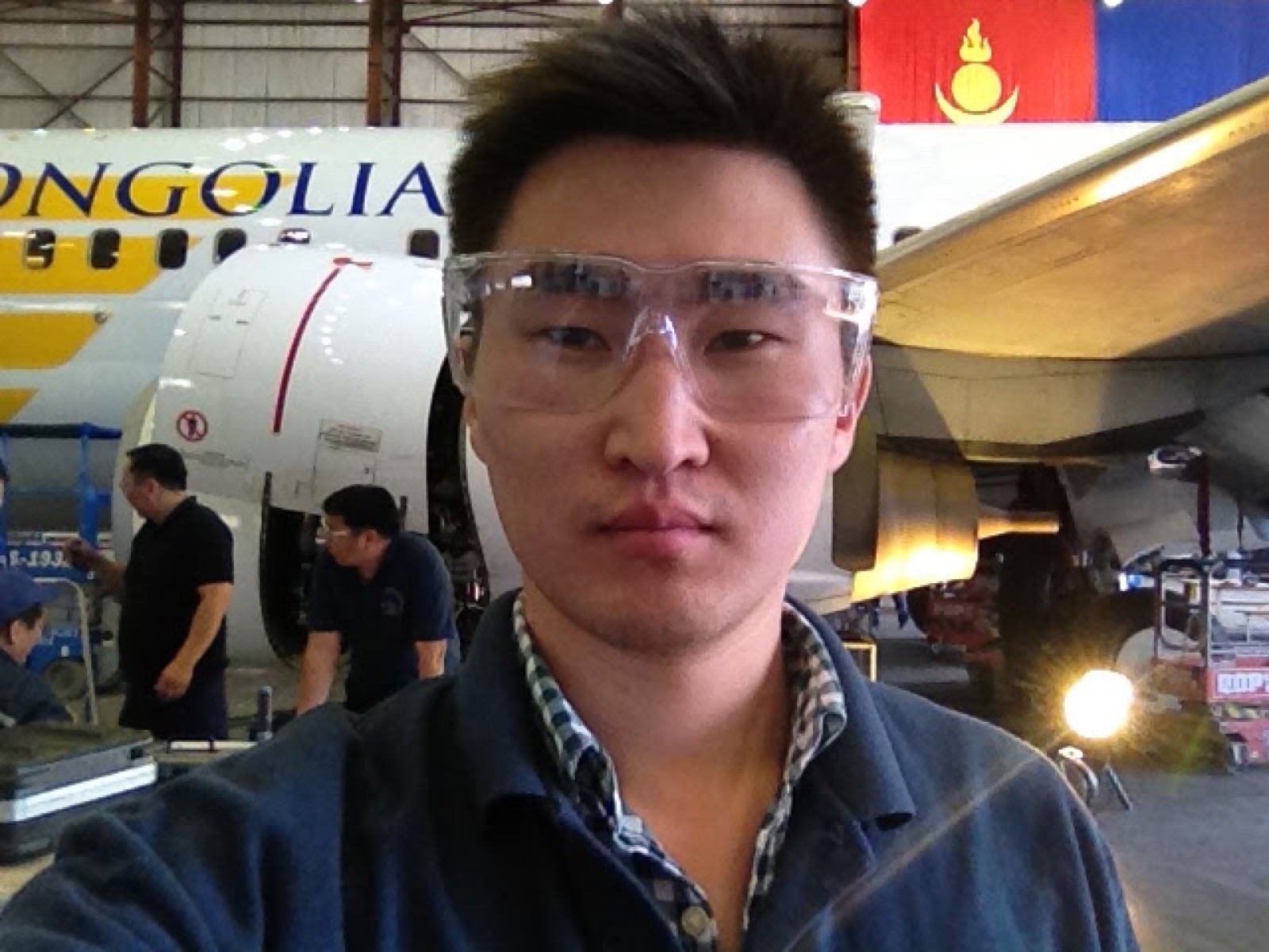 Ider-Od in safety glasses beside a MIAT aircraft
